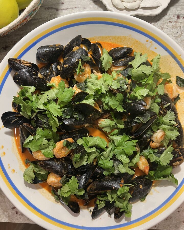 Shrimp and mussels in red curry coconut sauce with topped with fresh basil and cilantro