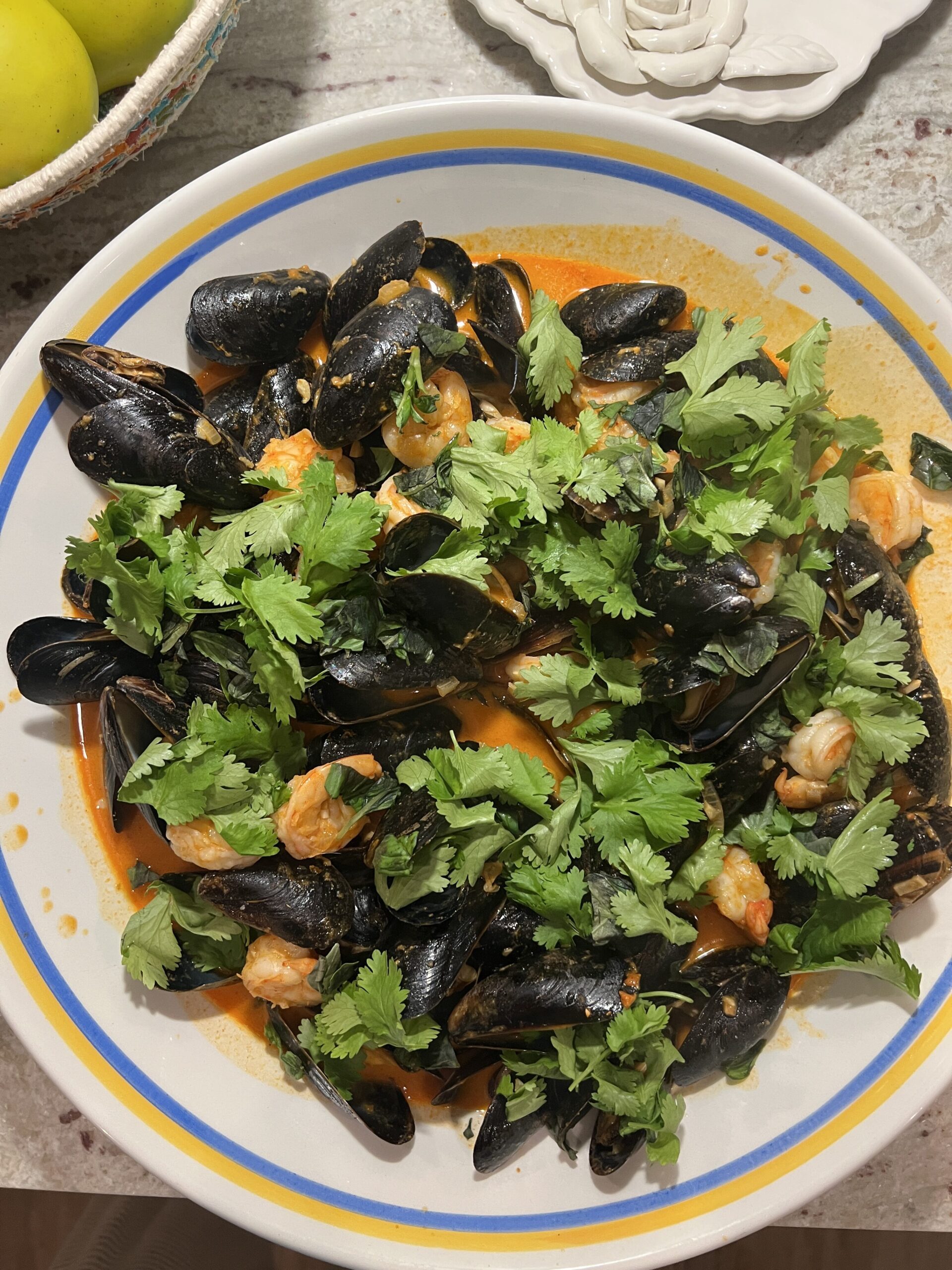 Shrimp and mussels in red curry coconut sauce with topped with fresh basil and cilantro