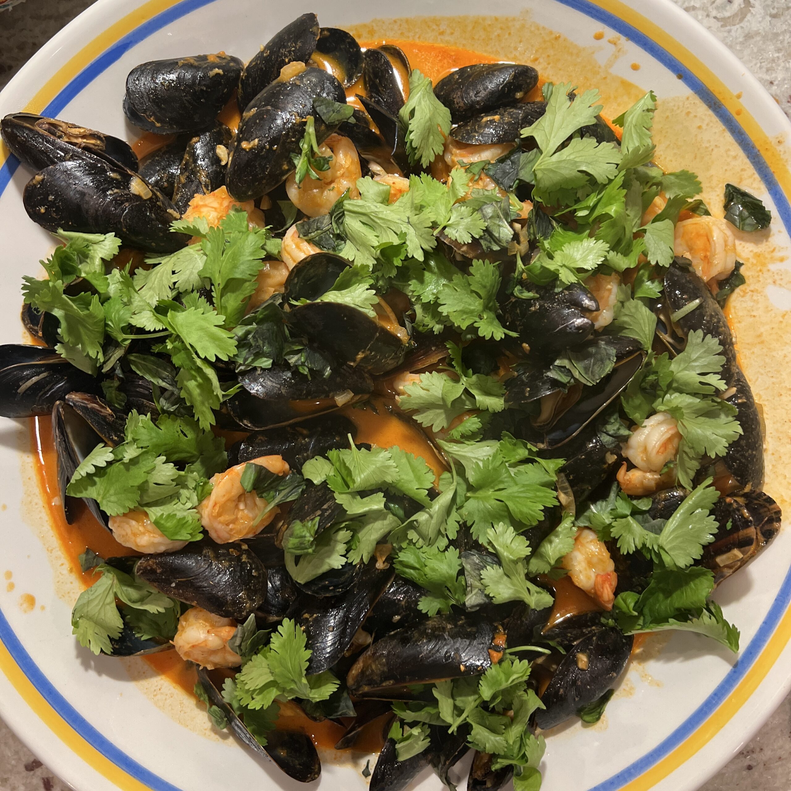 Shrimp and Mussels in a Thai red curry sauce topped with basil and cilantro